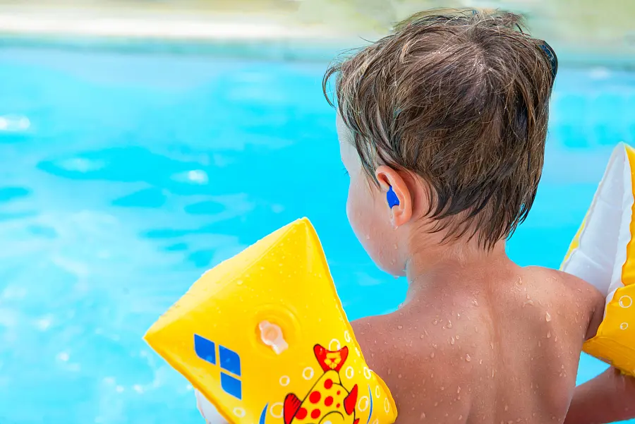 Personne en vacances à la piscine portant un appareil auditif résistant à l'eau