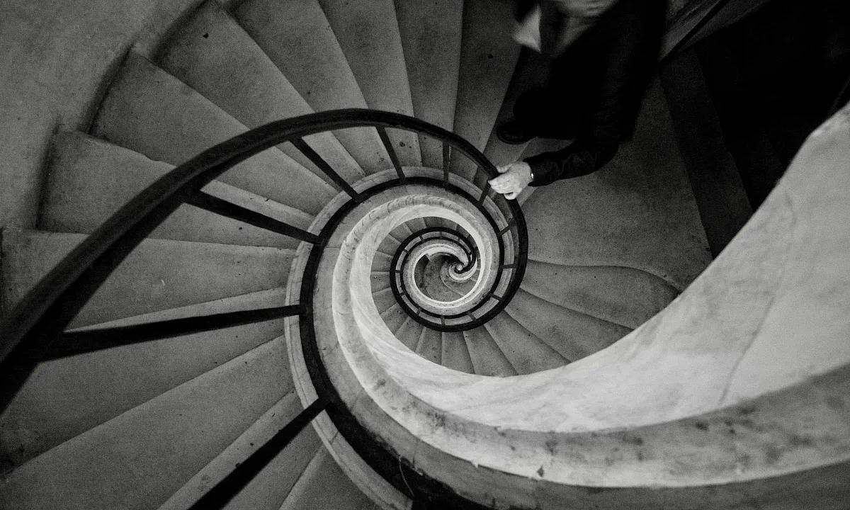 Escalier en colimaçon vu d'en haut, évoquant la sensation de vertige